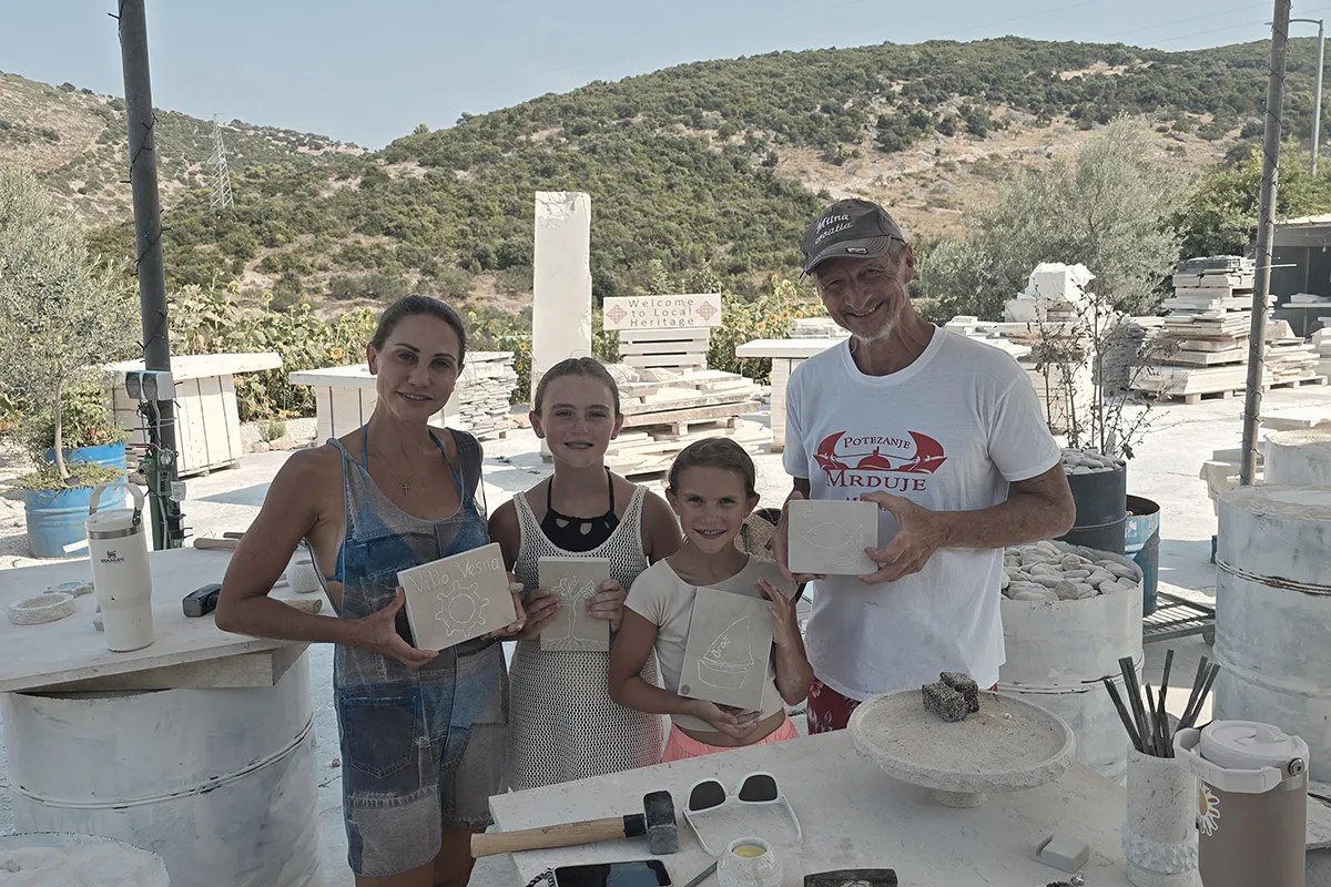 Family proudly showing their handmade Brač stone carvings at Journey Through Stone