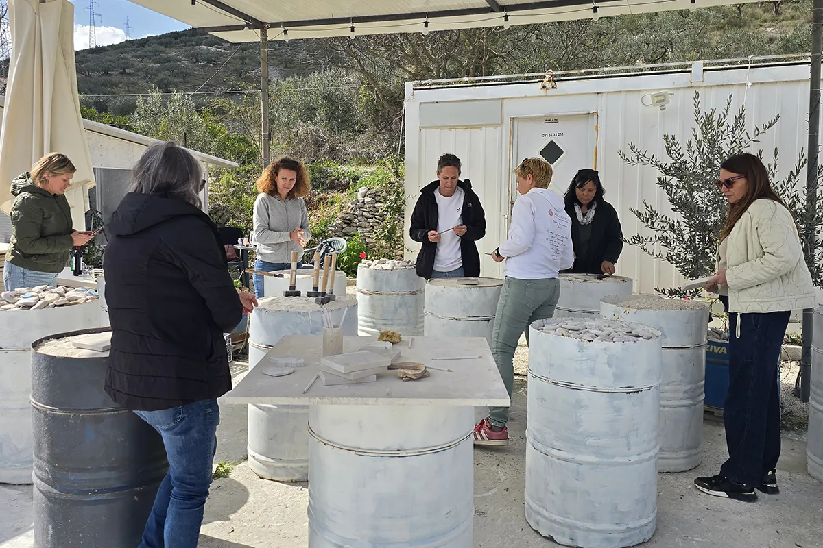 Stone carving experience on Brač with guests working in a stonemason’s workshop